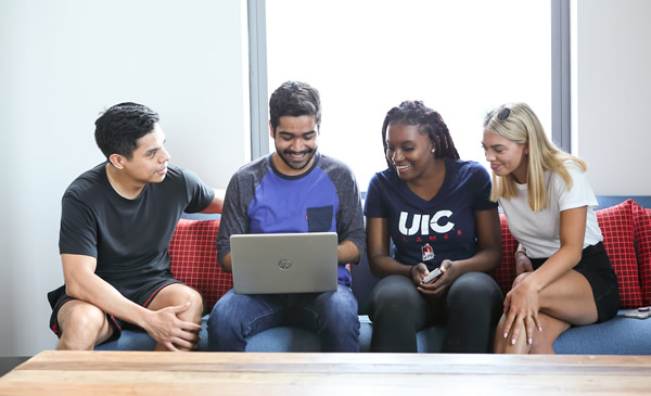 Group of students looking at laptop.